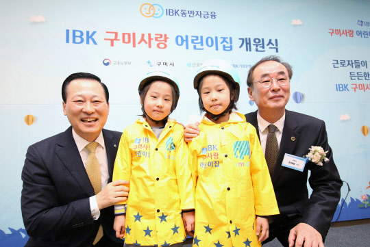 26일 경북 구미에서 열린 'IBK 구미사랑 어린이집 개원식'에서 김도진 기업은행장(왼쪽 끝)과 장세용 구미시장(오른쪽 끝)이 어린이들에게 선물을 전달하고 기념촬영을 하고 있다. IBK기업은행 제공
